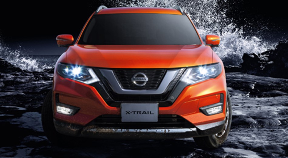 Front view of orange X-Trail standing in shallow water